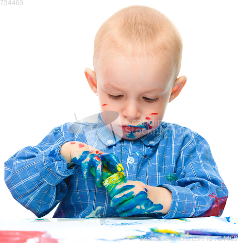 Image of Little boy is playing with paints