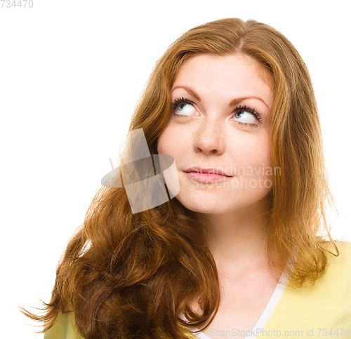 Image of Young happy woman is looking up and smile