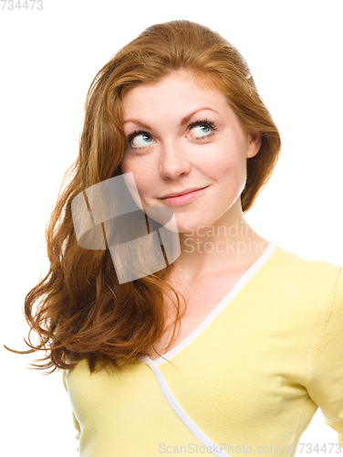 Image of Young happy woman is looking up and smile