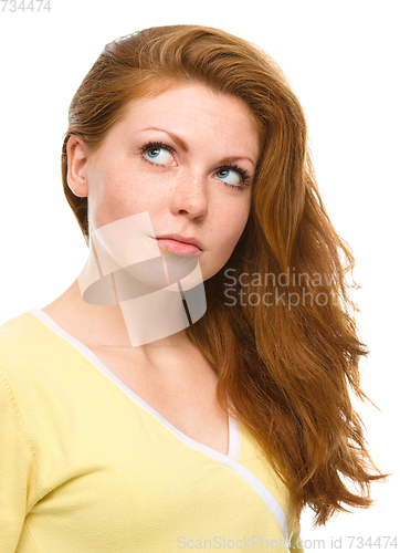 Image of Young happy woman is looking up and smile