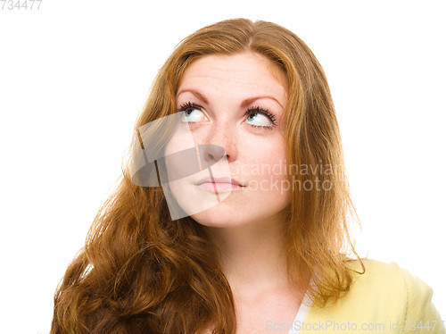 Image of Young happy woman is looking up and smile