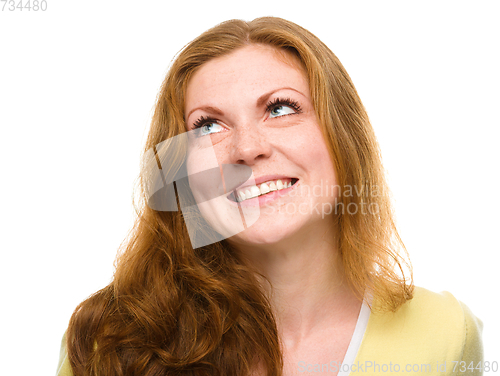 Image of Young happy woman is looking up and smile