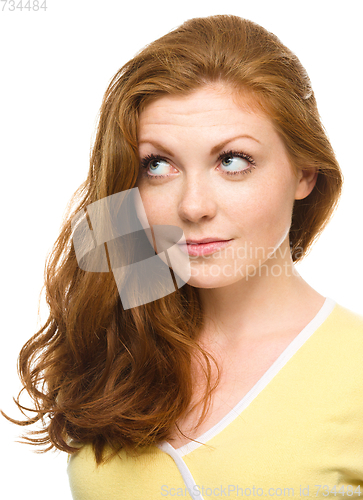 Image of Young happy woman is looking up and smile