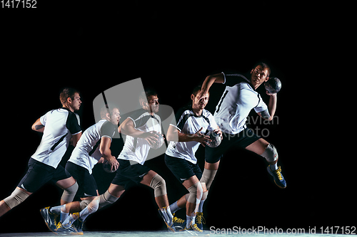 Image of Young handball player against dark studio background in strobe light