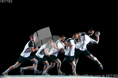 Image of Young handball player against dark studio background in strobe light