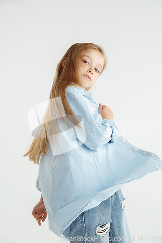 Image of Little smiling girl posing in casual clothes on white studio background