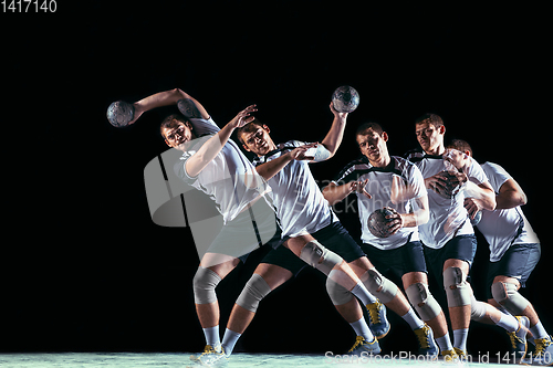 Image of Young handball player against dark studio background in strobe light