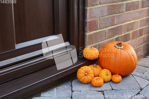 Image of Large orange pumpkin and mini pumpkins as seasonal decorations