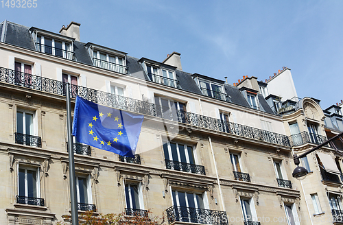 Image of EU flag flies against a backdrop of housing in Paris