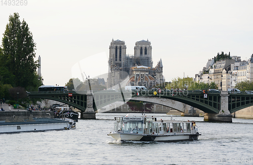Image of Pont Sully bridge spans the river Seine beyond river traffic in 