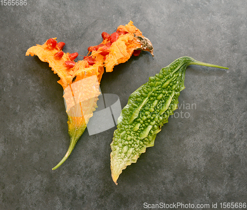 Image of Split orange bitter gourd and a green bitter melon