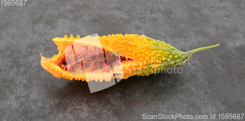 Image of Orange bitter gourd, with ridged flesh, split open