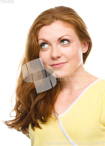 Image of Young happy woman is looking up and smile