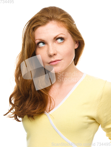 Image of Young happy woman is looking up and smile