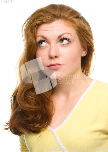 Image of Young happy woman is looking up and smile