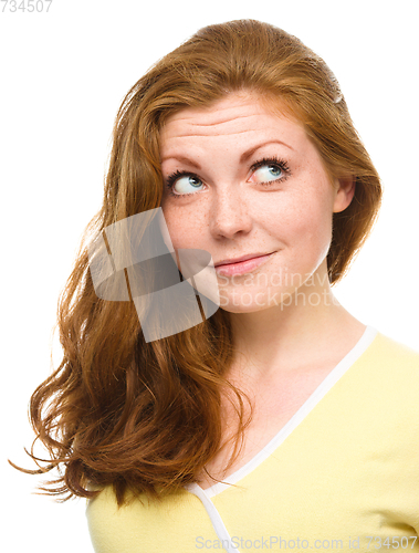 Image of Young happy woman is looking up and smile