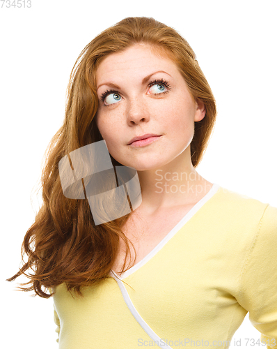 Image of Young happy woman is looking up and smile