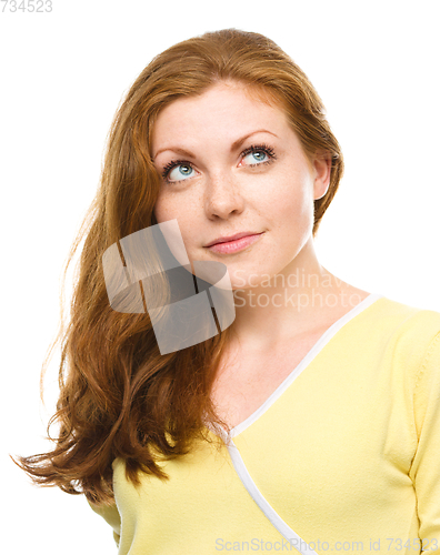 Image of Young happy woman is looking up and smile