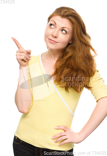 Image of Portrait of a young woman pointing to the left