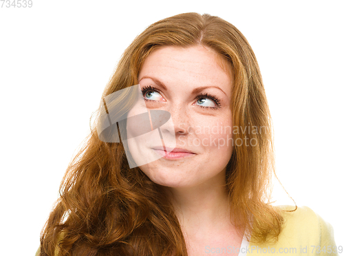 Image of Young happy woman is looking up and smile