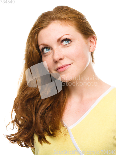 Image of Young happy woman is looking up and smile