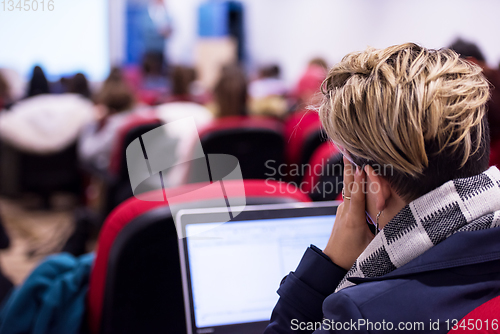 Image of businesswoman using laptop computer during seminar