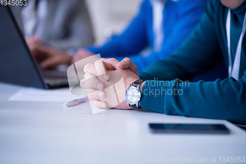 Image of Business man writing notes while working on laptop