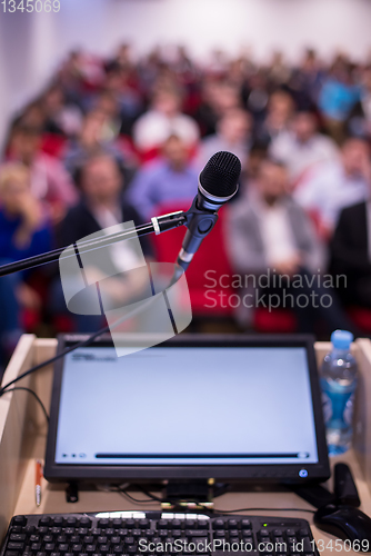 Image of laptop computer and microphone at podium