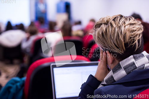 Image of businesswoman using laptop computer during seminar