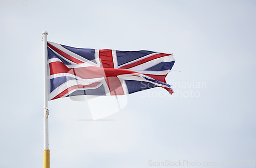 Image of Union Jack flag representing United Kingdom, flies against a lig