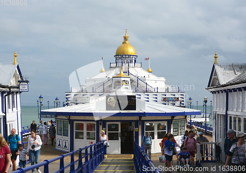 Image of View down Eastbourne pier with tourists walking around the Victo