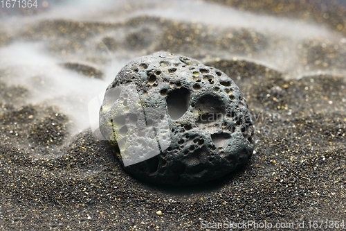 Image of Smoke whirling around small meteorite stone