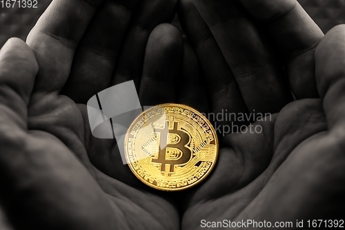 Image of Physical bitcoin held in hands close up photo in selective colors