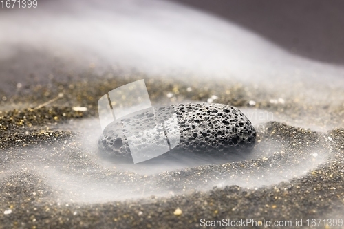 Image of Smoke whirling around small meteorite stone