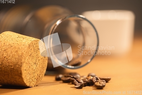 Image of Roasted coffee beans on table with jar