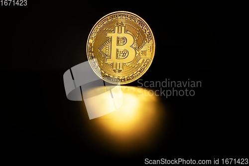 Image of Physical shiny bitcoin agains dark background