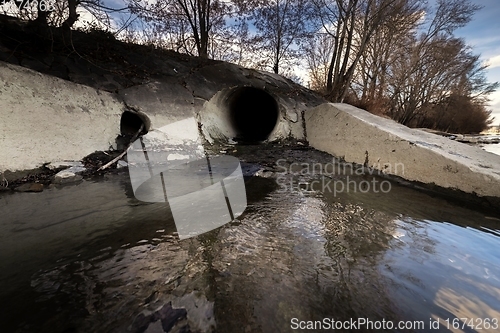 Image of Large sewage tunnel with filth flowing out