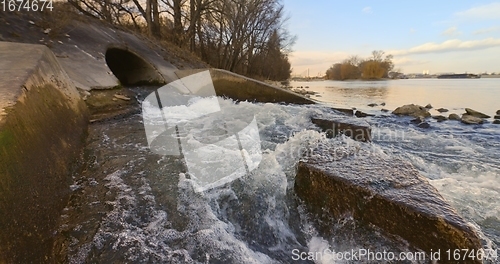 Image of Large sewage tunnel with filth flowing out