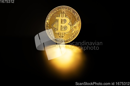 Image of Physical shiny bitcoin agains dark background