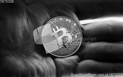 Image of Physical bitcoin held in hands closeup in black and white