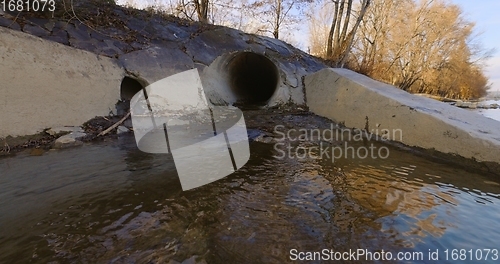 Image of Large sewage tunnel with filth flowing out