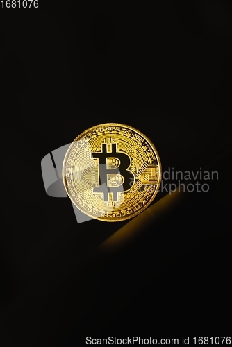 Image of Physical shiny bitcoin agains dark background