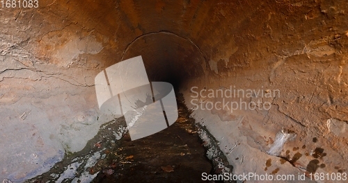 Image of Large sewage tunnel with filth flowing out