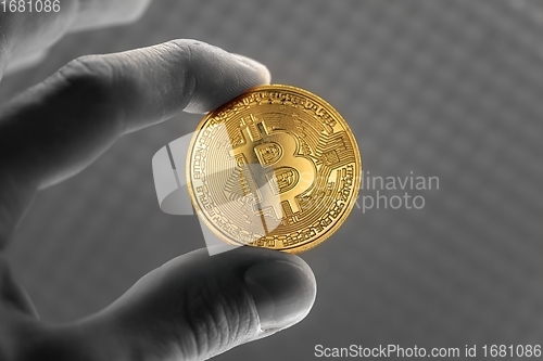 Image of Physical bitcoin held in hands close up photo in selective colors