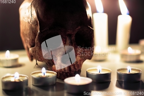 Image of Human skull against dark background in candle light closeup