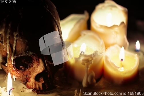 Image of Human skull against dark background in candle light closeup