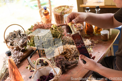 Image of potion bottle in hand of herbalist