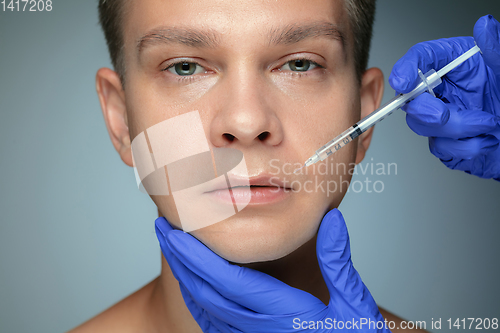 Image of Close-up portrait of young man isolated on grey studio background