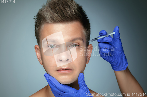 Image of Close-up portrait of young man isolated on grey studio background
