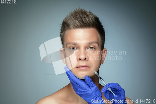 Image of Close-up portrait of young man isolated on grey studio background